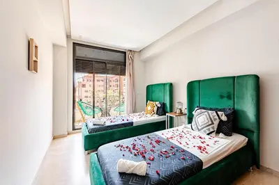 two beds in a room with green headboards at la cocon paisible de Marrakech in Marrakech