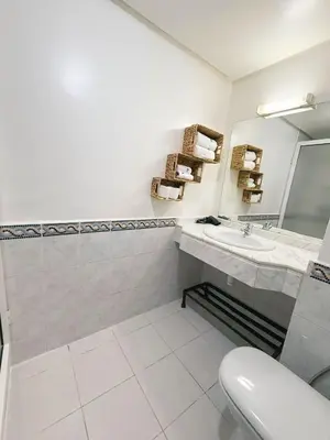 a white bathroom with a sink and a mirror at Ambre in Marrakech