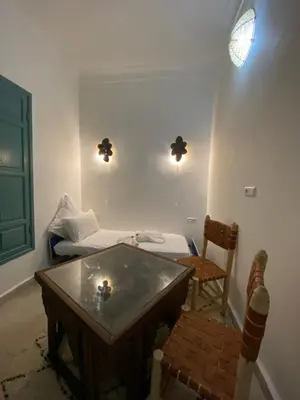 a room with a table and a bed and a chair at Riad Dar Khalti Privatisation in Marrakech