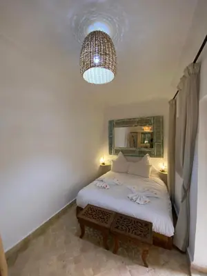 a bedroom with a bed and a chandelier at Riad Dar Khalti Privatisation in Marrakech