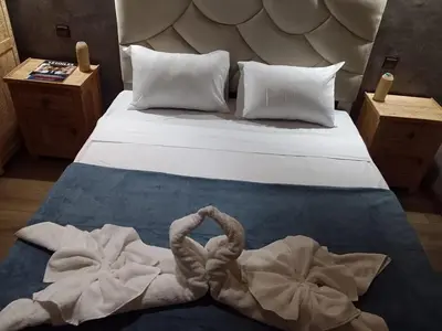 a bed with two swan towels on it at Riad Raphia in Marrakech