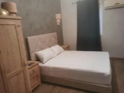 a bedroom with a white bed and a dresser at Riad Raphia in Marrakech