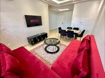 a living room with a red couch and a table at Chic Appartement Marrakech in Marrakech
