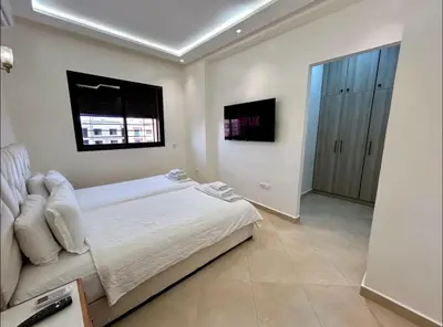 a white bedroom with a bed and a window at Chic Appartement Marrakech in Marrakech