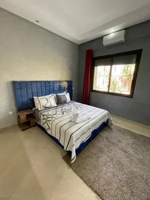 a bedroom with a large blue bed with a window at Deluxe Private Villa in Marrakech