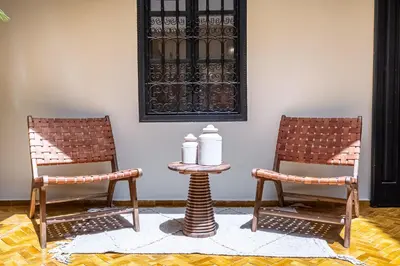 two chairs and a table with two containers on it at Riad Nayl Medina & Spa in Marrakech