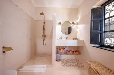 a bathroom with a shower and a sink and a mirror at Riad Nayl Medina & Spa in Marrakech