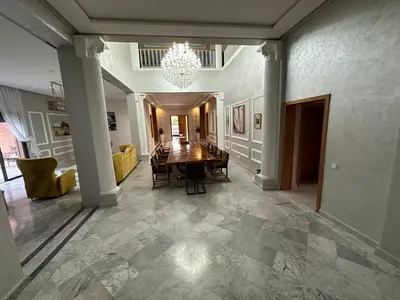 a dining room with a table and a chandelier at Villa à la palmeraie in Marrakech