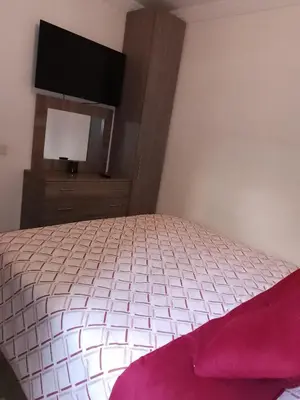 a bedroom with a bed with a tv on the wall at Appartement aux portes de Marrakech in Marrakech