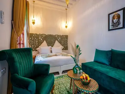 a living room with a bed and a couch at Riad Dar Al-Famila & Spa in Marrakech