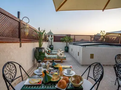 a table and chairs with food on a balcony at Riad Dar Al-Famila & Spa in Marrakech