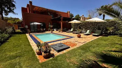 a swimming pool in front of a house at Dar Nadim sur le Golf de Samanah in Marrakech