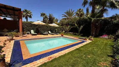 a swimming pool in a yard with palm trees at Dar Nadim sur le Golf de Samanah in Marrakech