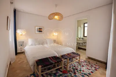 a bedroom with a white bed and a mirror at Dar Nadim sur le Golf de Samanah in Marrakech