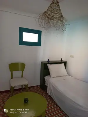a bedroom with a bed and a chair and a chandelier at Riad rajad Marrakech in Marrakech