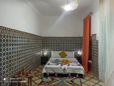 a bedroom with a bed with a patterned wall at Riad rajad Marrakech in Marrakech