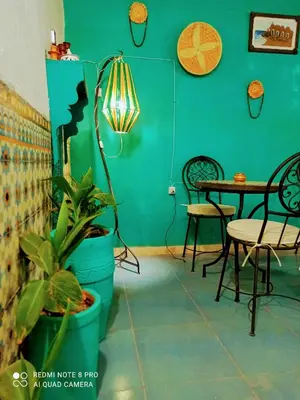 a green room with a table and a potted plant at Riad rajad Marrakech in Marrakech
