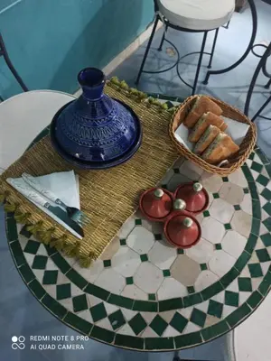 a table with a basket of tomatoes and a knife at Riad rajad Marrakech in Marrakech