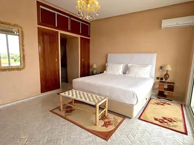 a bedroom with a white bed and a table at Palais Bahida in Marrakech