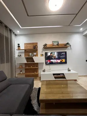 a living room with a couch and a tv on a wall at Cossy Inn in Marrakech