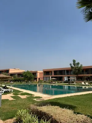 a large swimming pool in front of a building at Luxueux Appartement Domaine de Noria, Wifi, Clim, Piscine, Résidence Privée in Marrakech