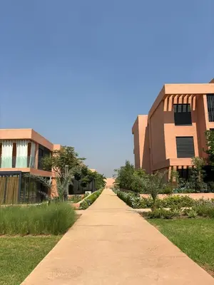 a walkway between two buildings in front of a building at Luxueux Appartement Domaine de Noria, Wifi, Clim, Piscine, Résidence Privée in Marrakech