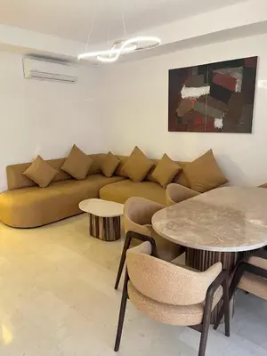 a living room with a couch and a table at Luxueux Appartement Domaine de Noria, Wifi, Clim, Piscine, Résidence Privée in Marrakech