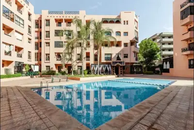 a swimming pool in front of a building at Appartement 5 piscine sport in Marrakech