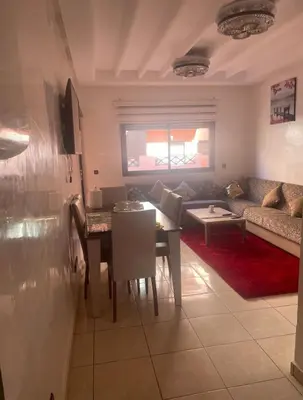 a living room with a table and a couch at Appartement 5 piscine sport in Marrakech
