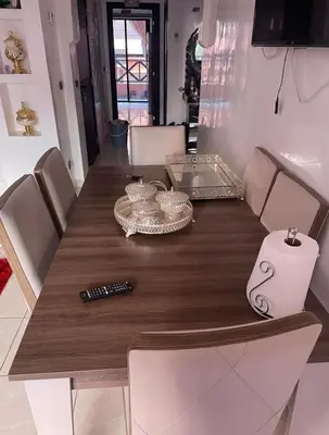 a dining room table with a wooden table and chairs at Appartement 5 piscine sport in Marrakech