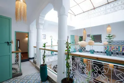 a lobby with a staircase with potted plants at Riad Lkhlil in Marrakech