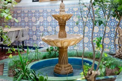 a fountain in the middle of a garden at Riad Lkhlil in Marrakech