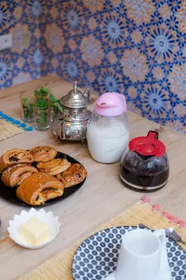 a table with a plate of pastries and a kettle at Riad Lkhlil in Marrakech