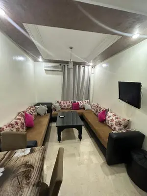 a living room with a large couch and a tv at le familial vous attend a L'Hivernage face Gare CTM in Marrakech
