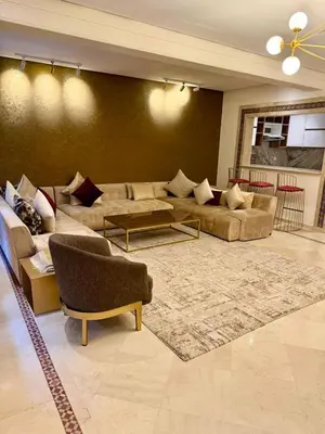 a living room with a couch and a table at Plaza Guéliz Prestige Apartment in Marrakech