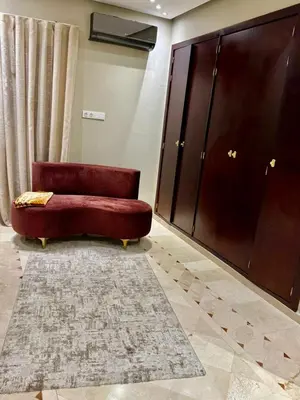 a red couch in a room with a large wardrobe at Plaza Guéliz Prestige Apartment in Marrakech