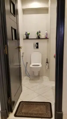 a bathroom with a toilet and a door with a rug at Appartement bijoux à gueliz in Marrakech