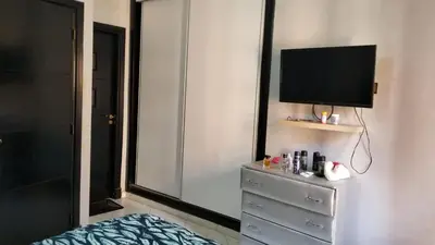 a bedroom with a dresser with a tv and a mirror at Appartement bijoux à gueliz in Marrakech
