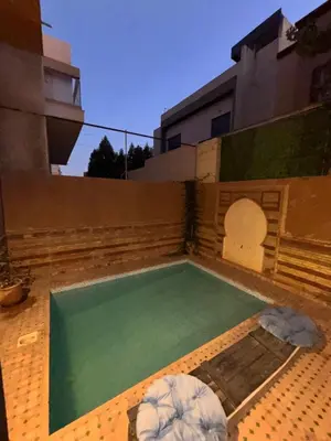 a swimming pool in the backyard of a house at Appartement dans villa jacuzzi in Marrakech