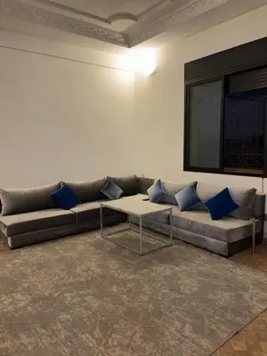a couch with blue pillows sitting in a room at Appartement dans villa jacuzzi in Marrakech