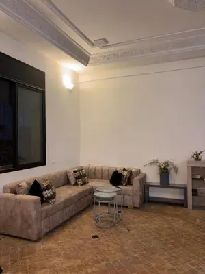 a living room with a couch and a table at Appartement dans villa jacuzzi in Marrakech