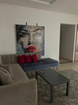 a living room with a couch and a painting at Appartement dans villa jacuzzi in Marrakech