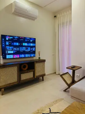 a living room with a large flat screen tv on a wall at Charmant et central in Marrakech