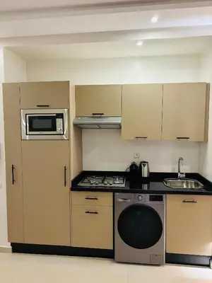 a kitchen with a stove and a microwave at Charmant et central in Marrakech
