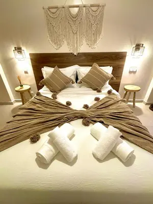 a large white bed with three rolled towels on it at Charmant et central in Marrakech