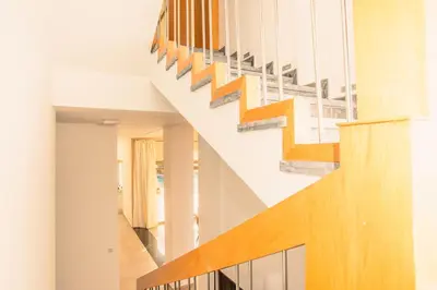 a staircase in a house with wood and white walls at Villa 5 Suites Modern with Ping Pong table and Heated Swimming pool in Marrakech