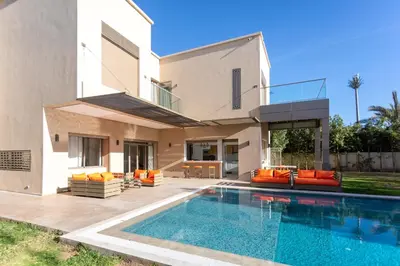 a house with a swimming pool in front of a house at Villa 5 Suites Modern with Ping Pong table and Heated Swimming pool in Marrakech