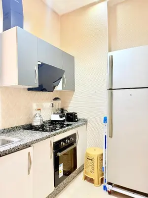 a kitchen with white cabinets and a refrigerator at Appart Abir2 N1 Confort Au Centre-ville in Marrakech