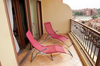 two pink chairs sitting on a balcony at Cosy cocon au coeur de Gueliz-Parking gratuit in Marrakech