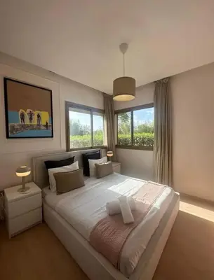 a bedroom with a large white bed with windows at Ali plaza marrakech in Marrakech